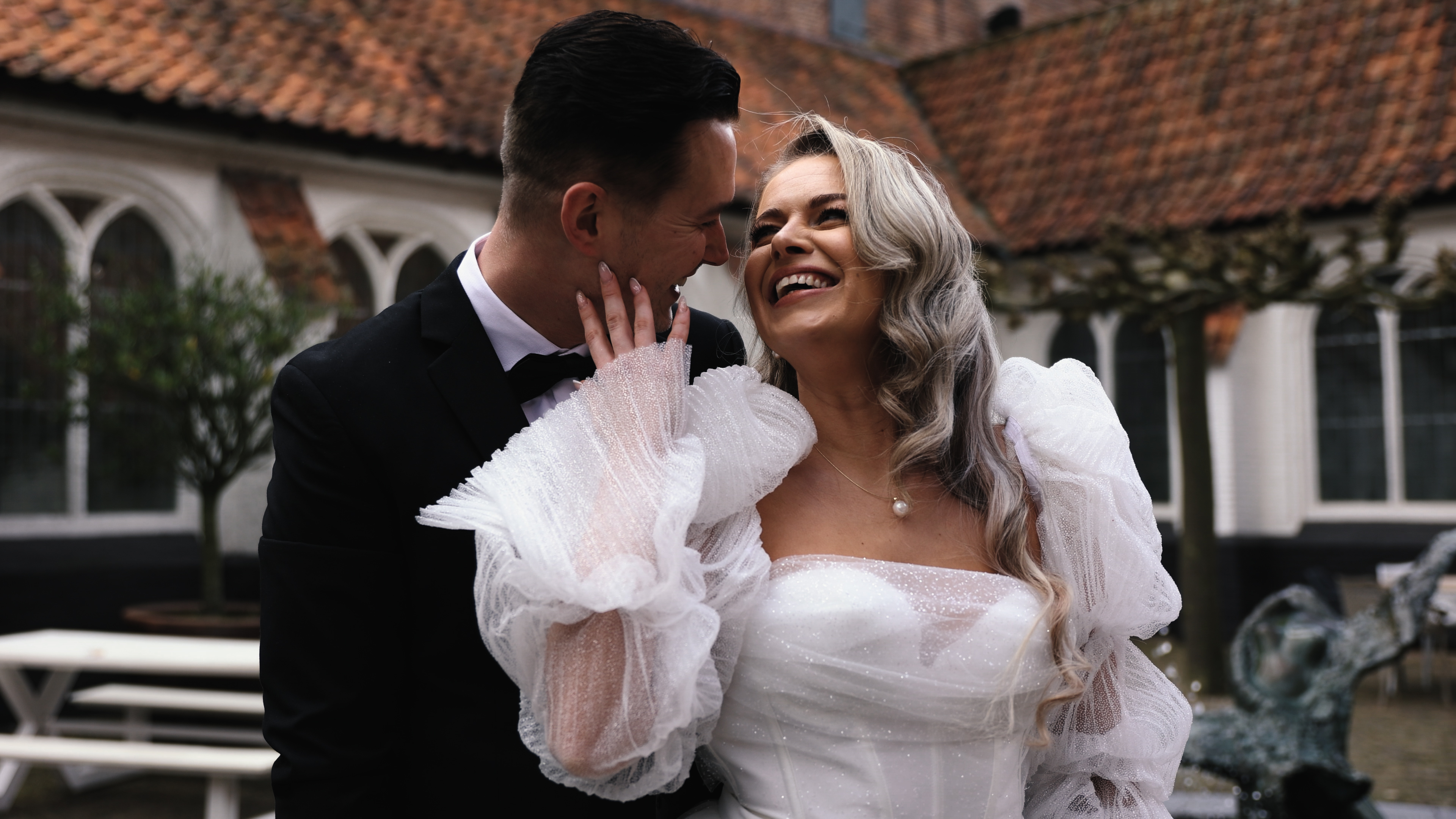 Lachende bruid naar bruidegom tijdens fotoshoot